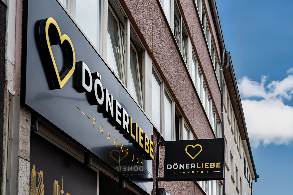 Das DönerLiebe-Schild mit goldenem Herz an der Fassade des Ladens in Frankfurt-Rödelheim.